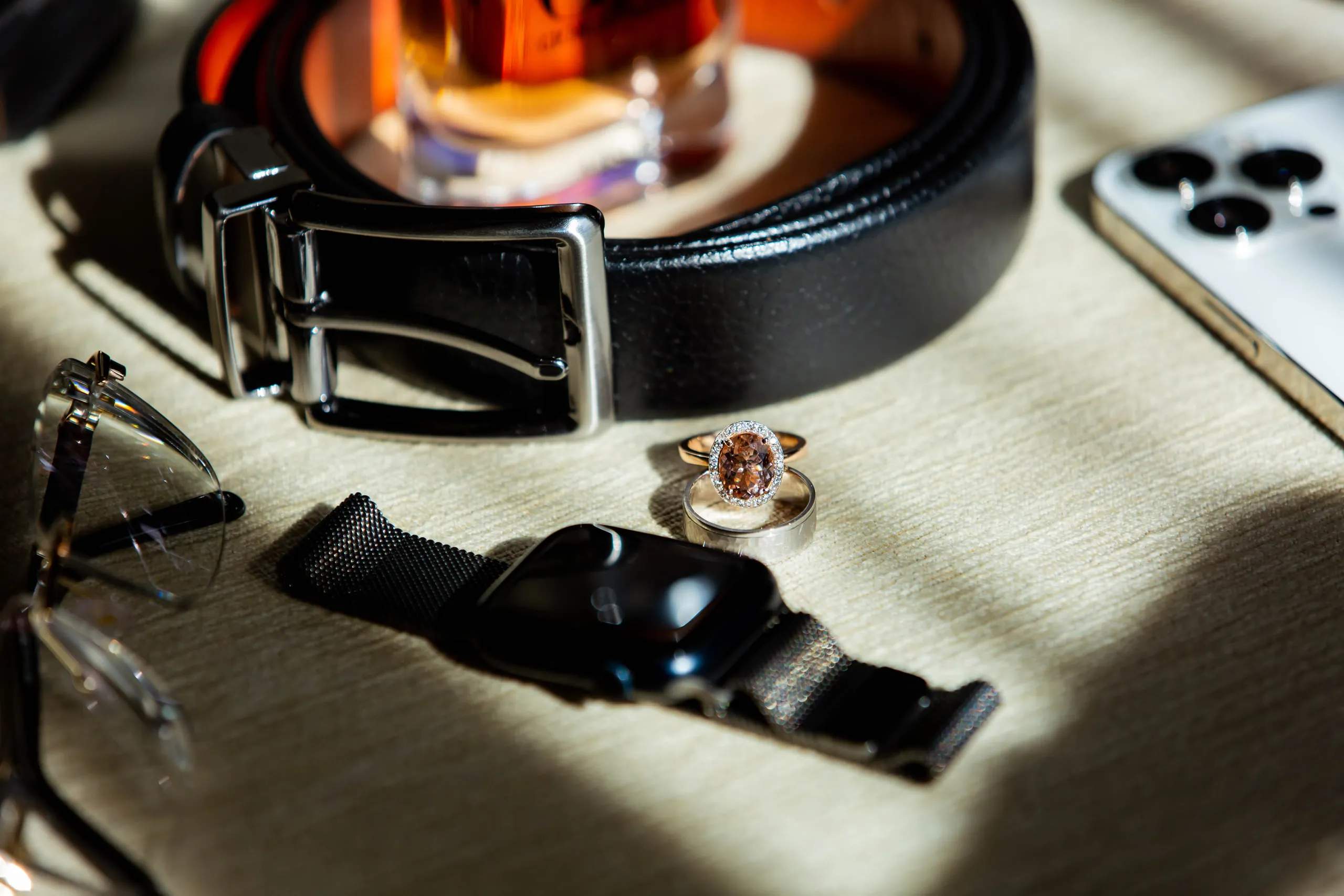The groom's belt, watch, ring, sunglasses and phone