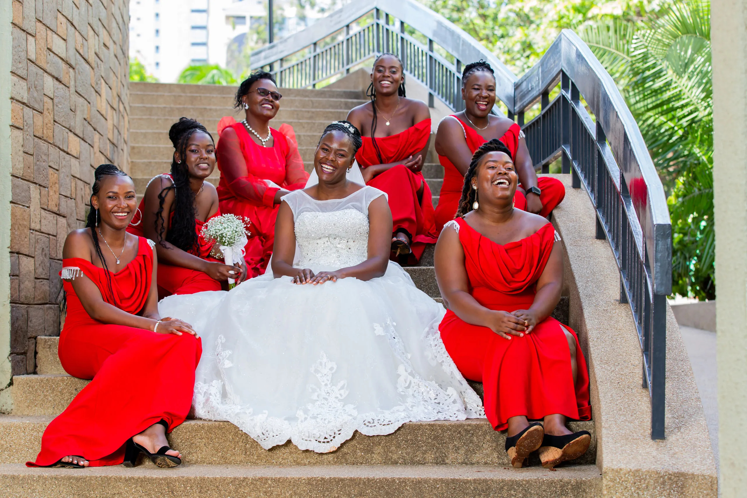 Bride and bridesmaids in red laughing on the steps