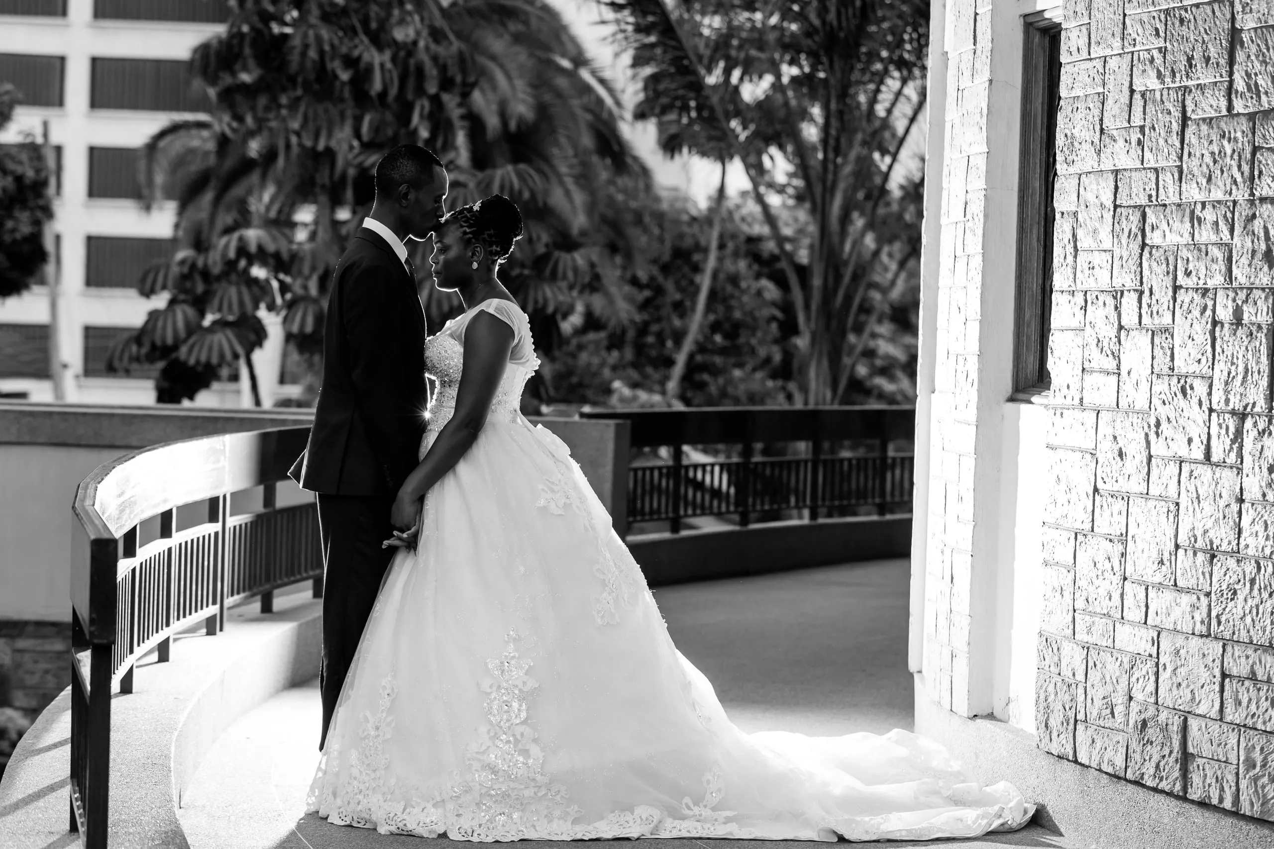 Bride and groom kissing on a balcony, in black and white