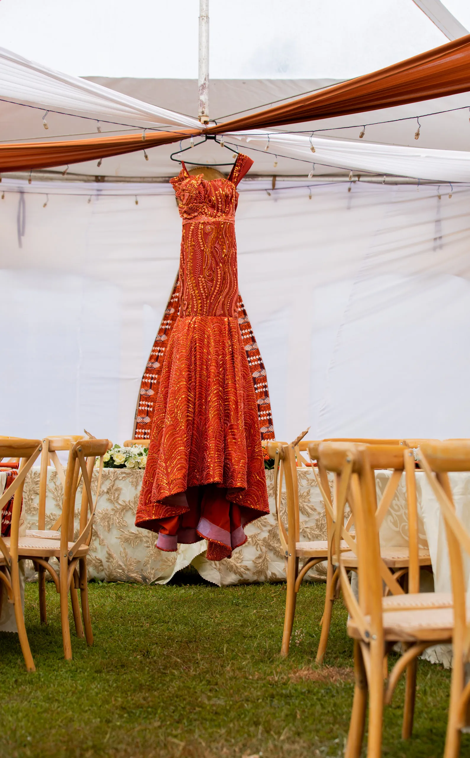 Orange gown hanging in a white tent
