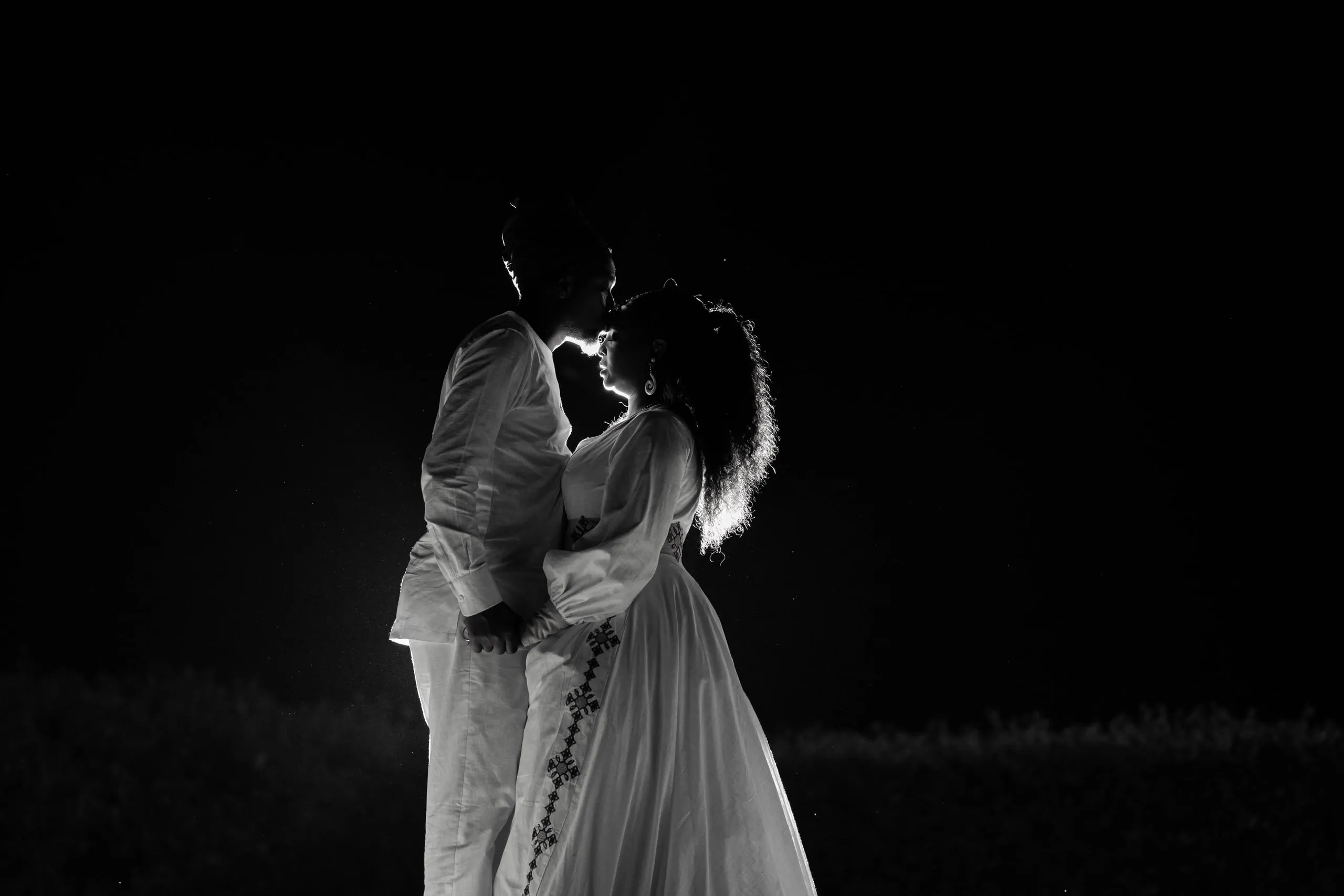 Silhouette of a couple about to kiss, in black and white