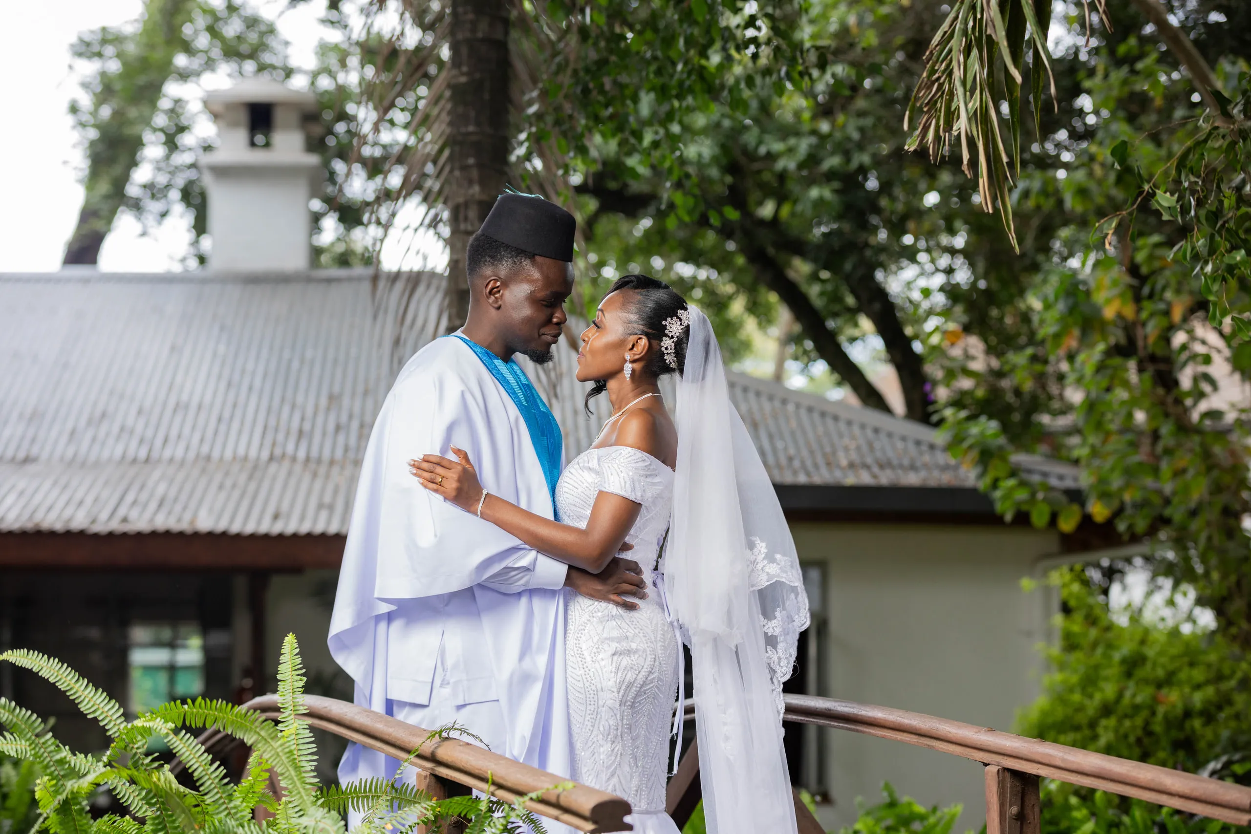 Bride and groom embracing on a garden bridge