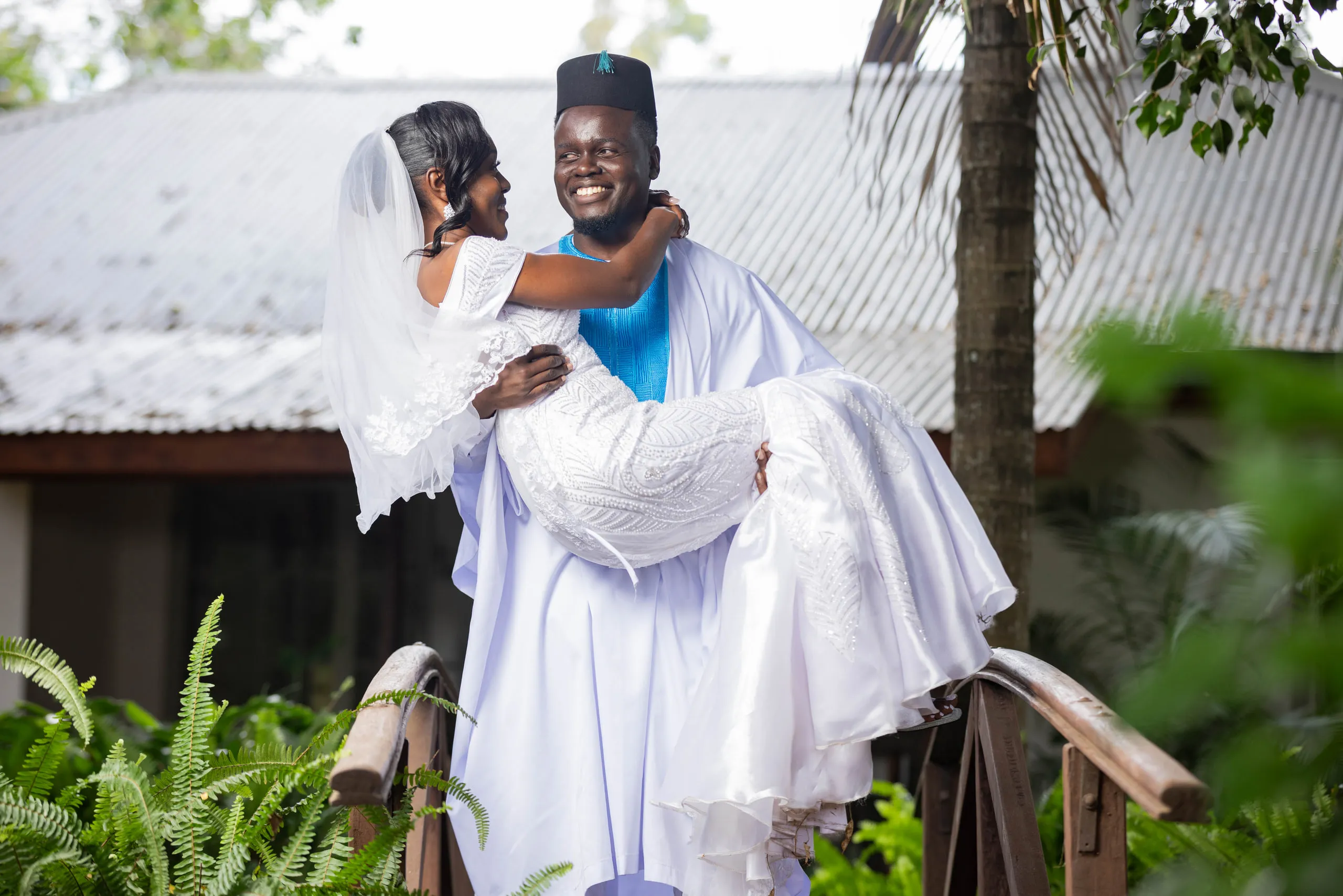 Groom carrying the laughing bride across the bridge