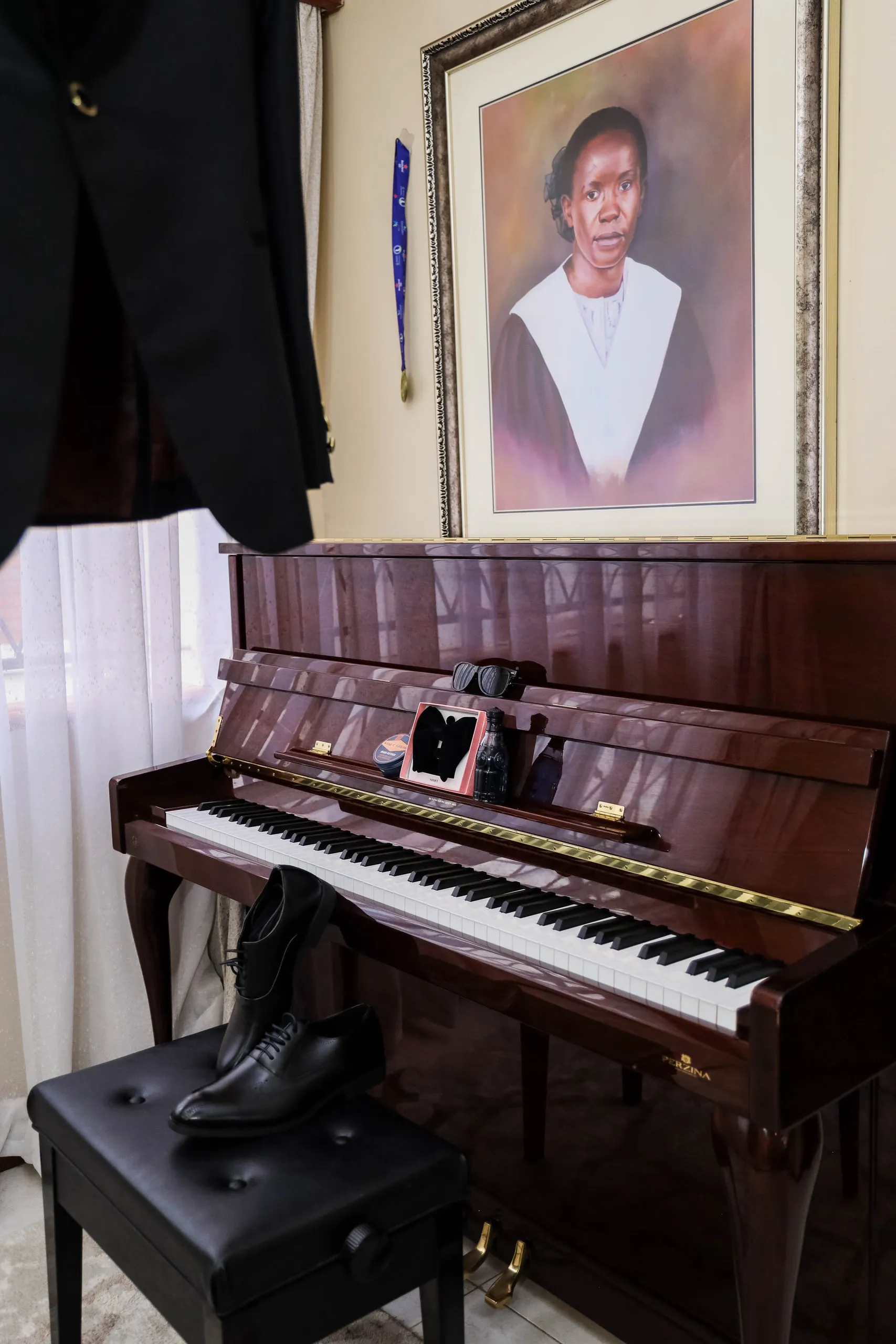 Groom's shoes on a piano stool under a portrait painting