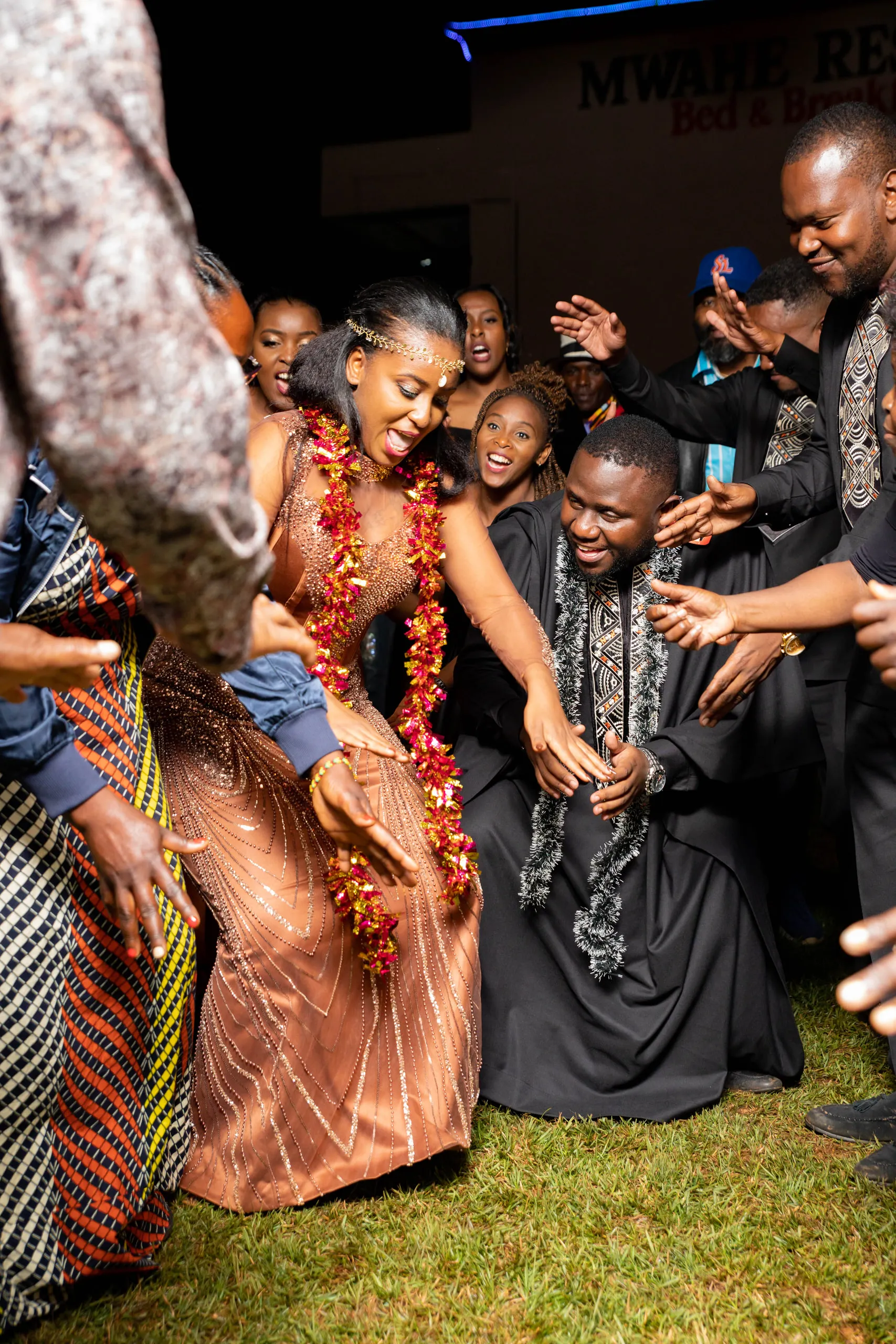 Bride in coral beads dancing among the guests at night