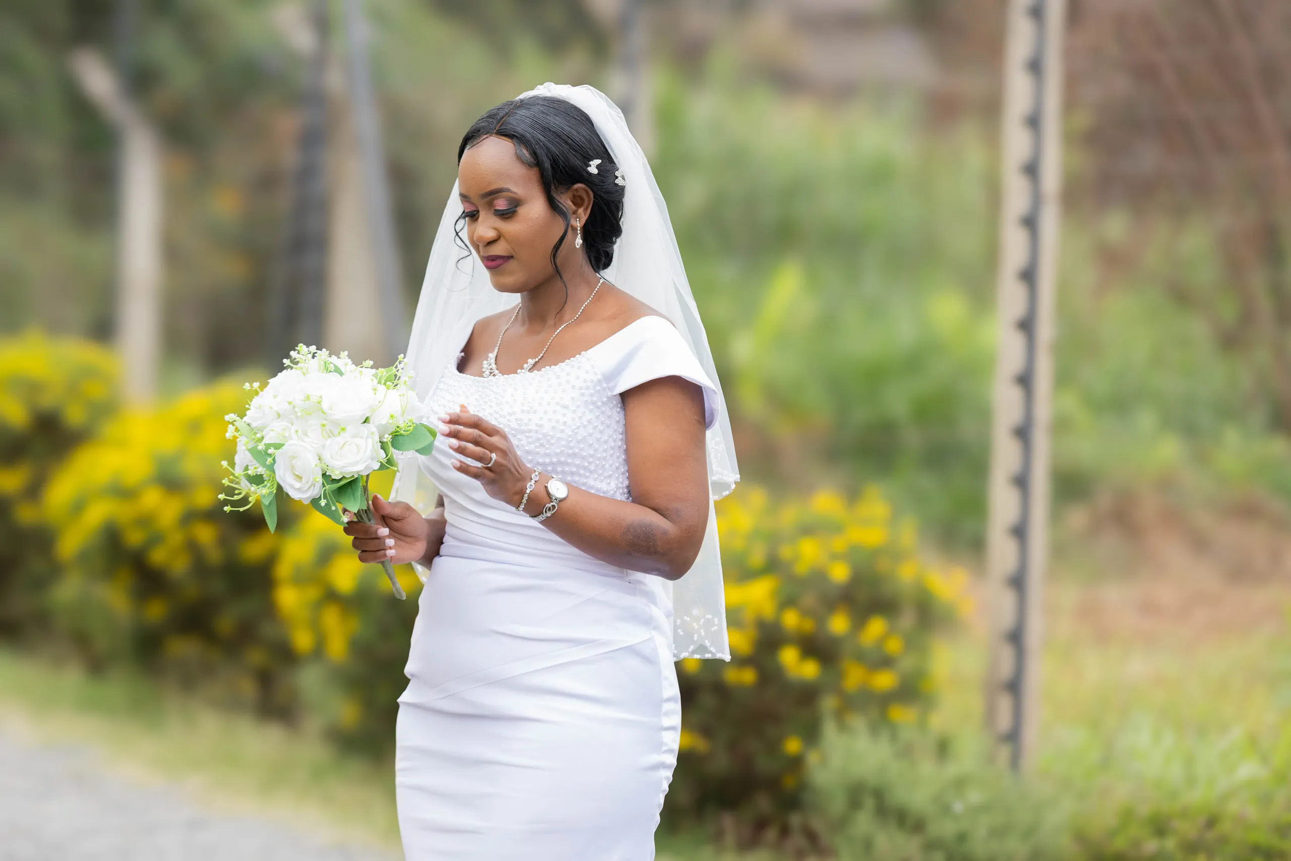 Bride with her bouquet beside yellow flowers