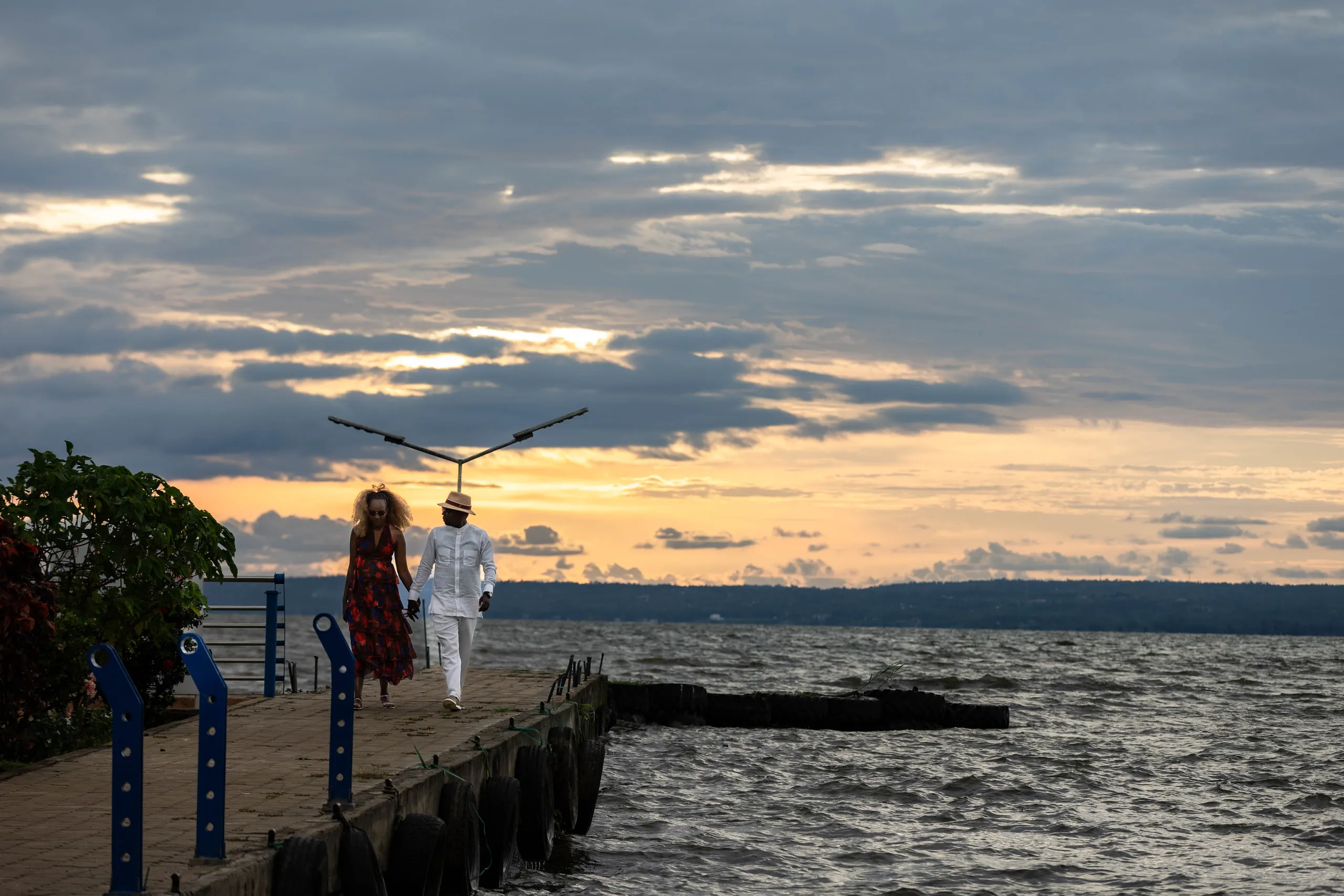 Couple walking along a jetty at sunset over the lake