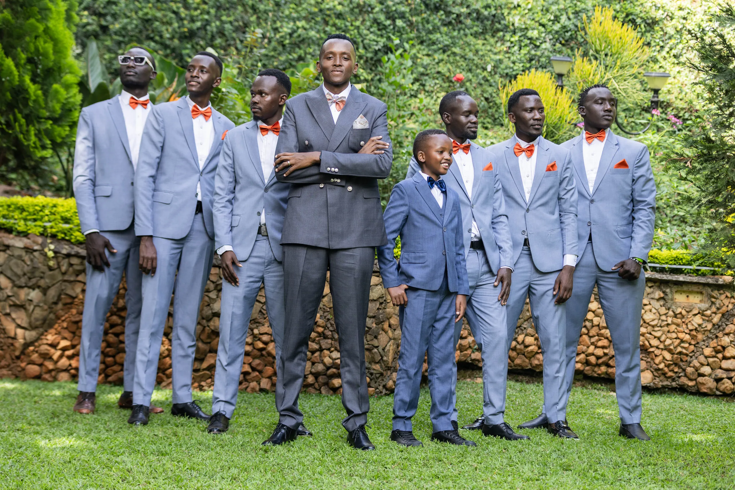 Groom and groomsmen with arms folded, the page boy in front