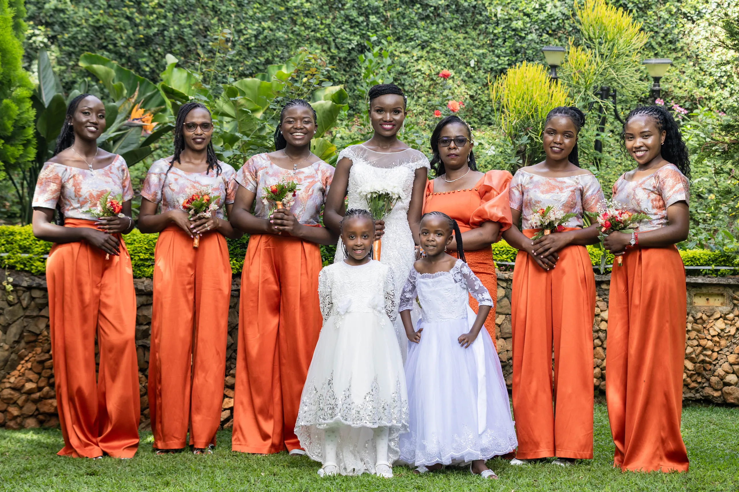 Bride with her bridesmaids in orange satin and two flower girls