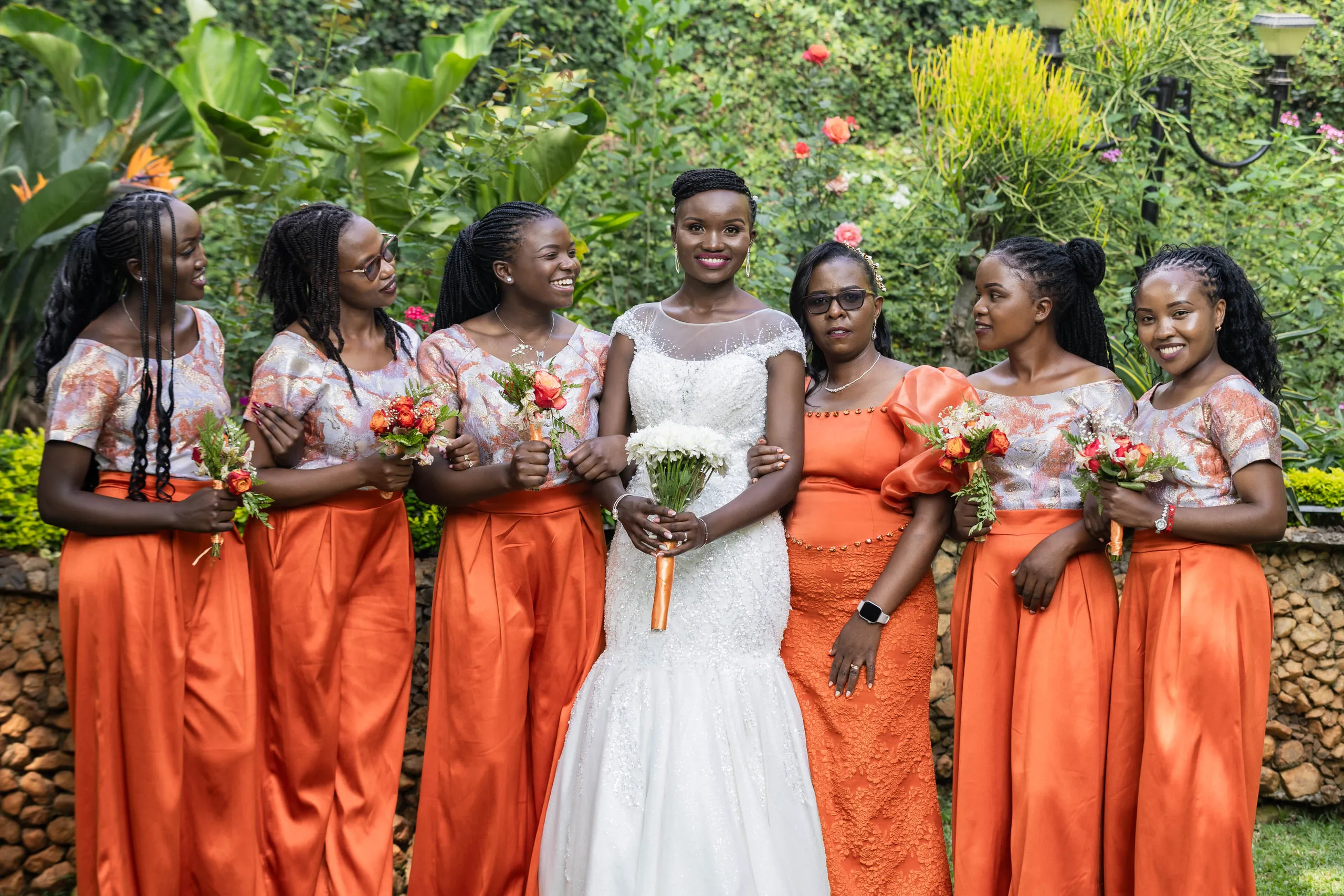 Bride laughing with her bridesmaids in orange