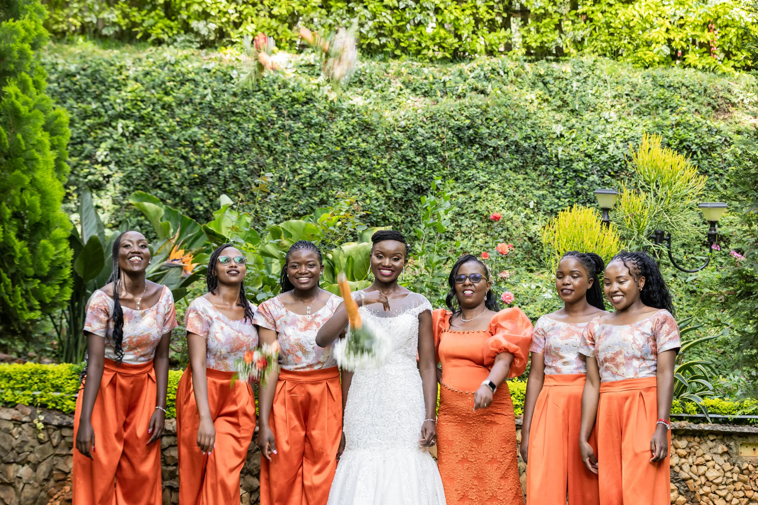Bride and bridesmaids cheering with their bouquets raised
