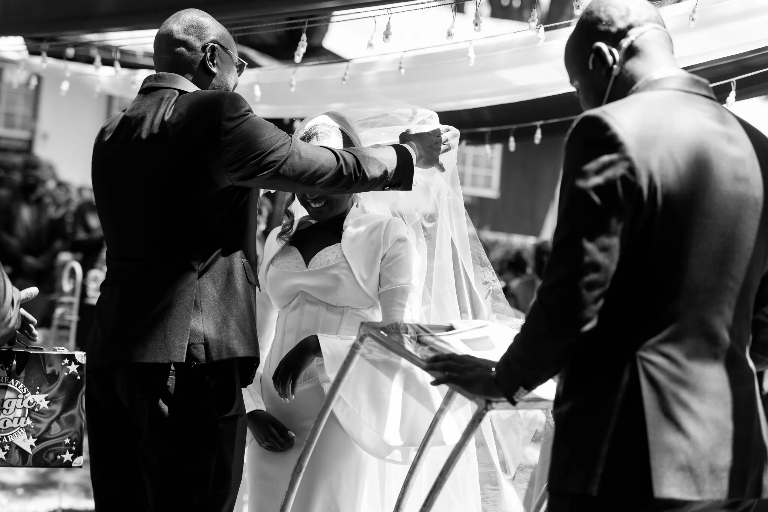 The bride's veil lifted at the front of the ceremony, in black and white
