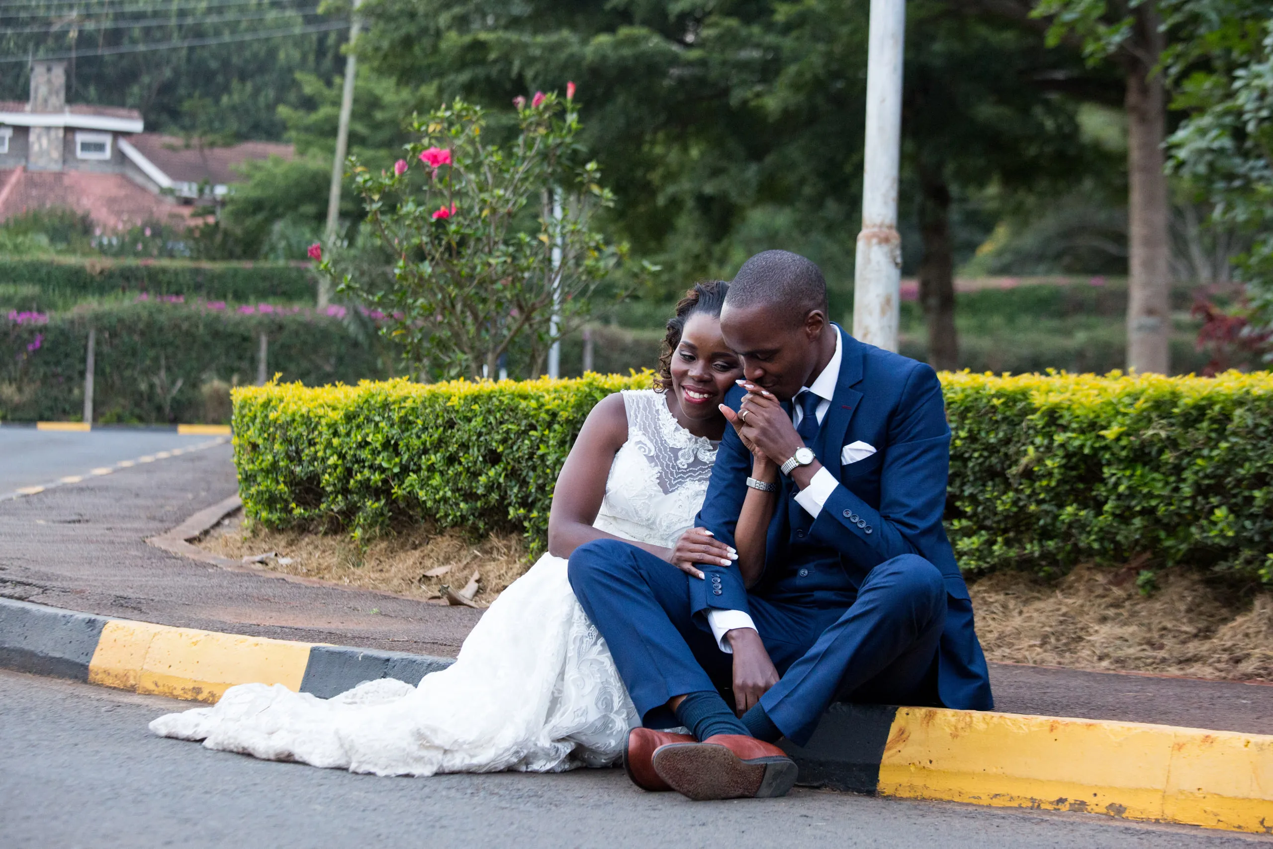 Bride and groom laughing together on a kerb