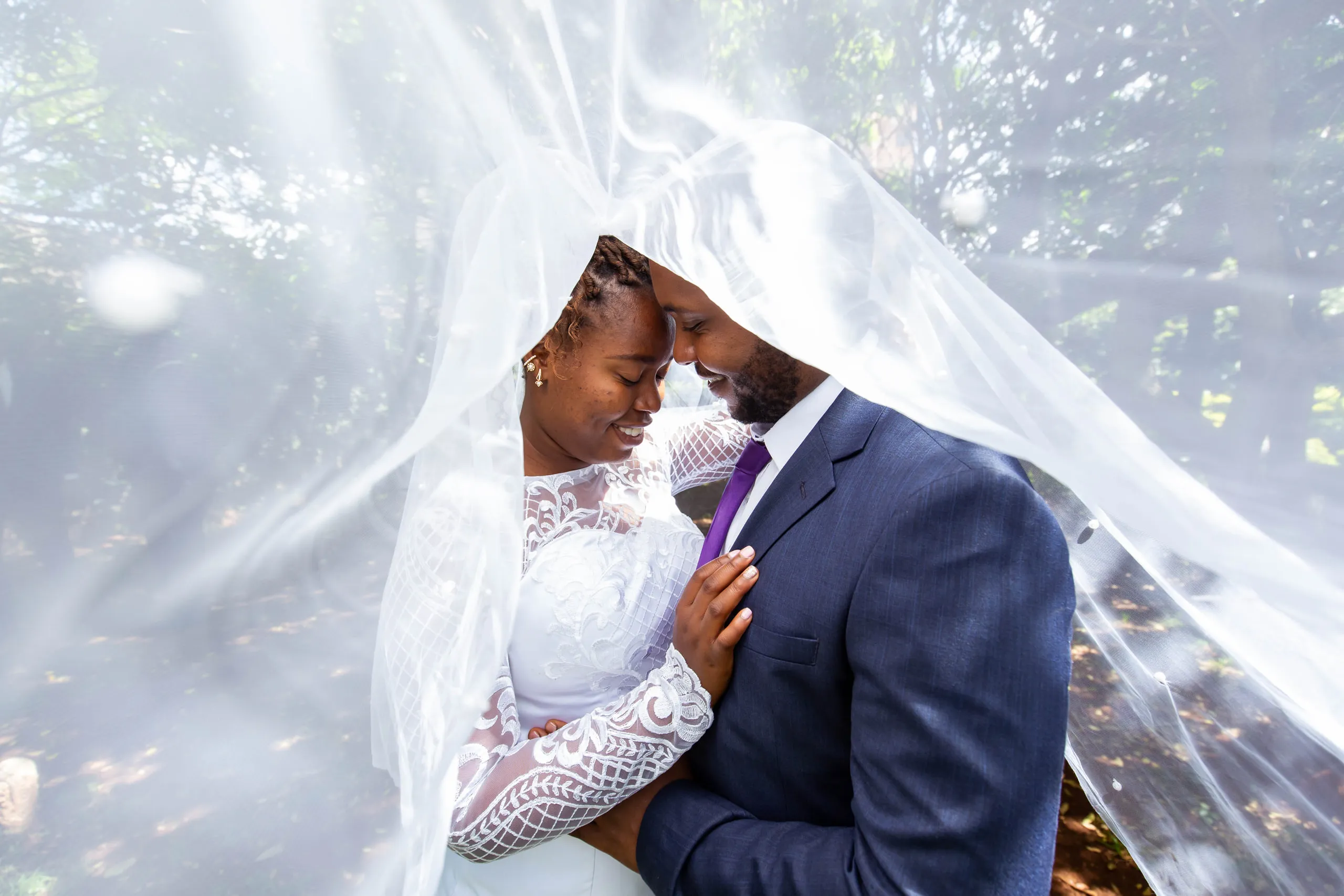 Bride and groom forehead to forehead under her veil