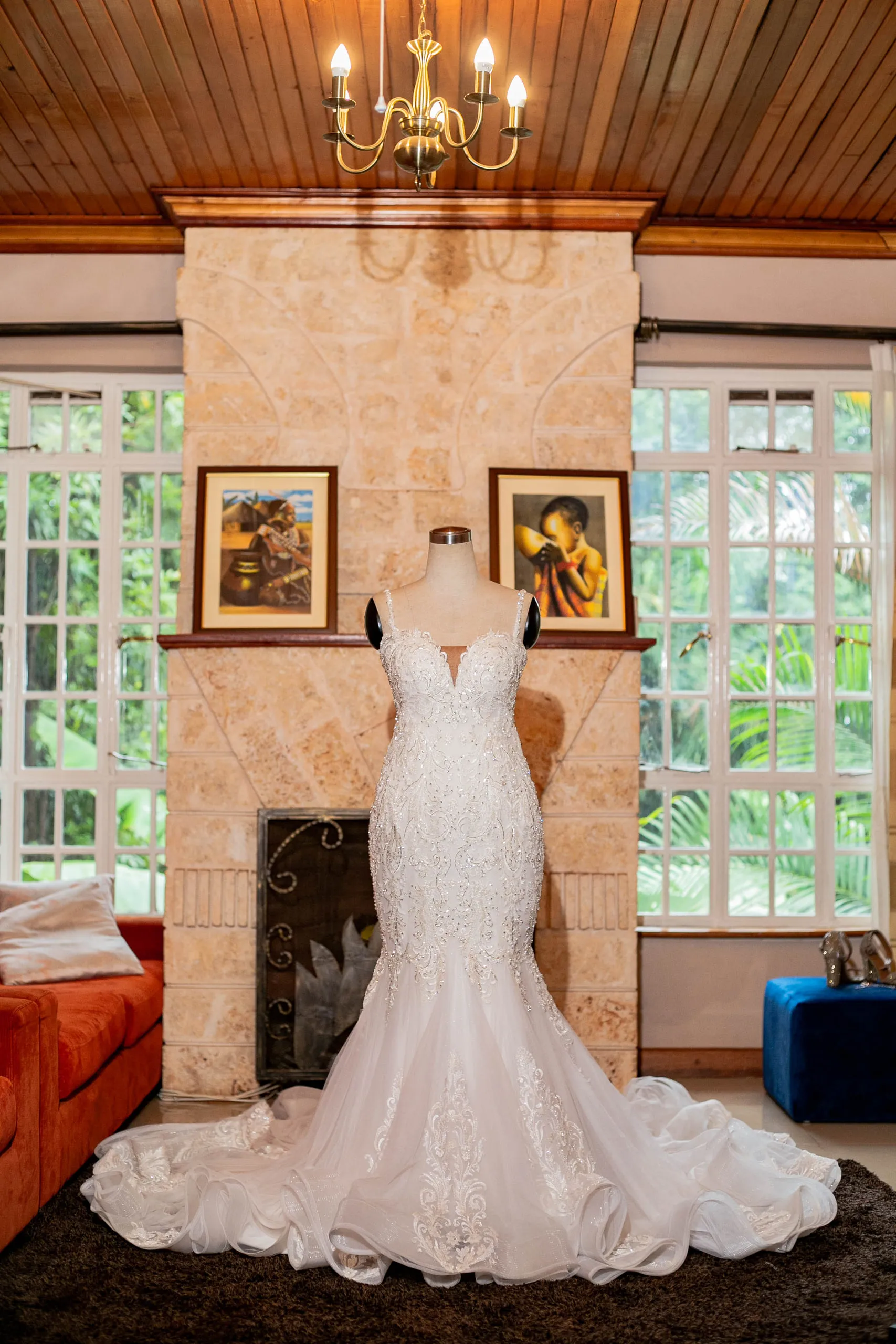 Mermaid wedding gown on a stand in front of a stone fireplace