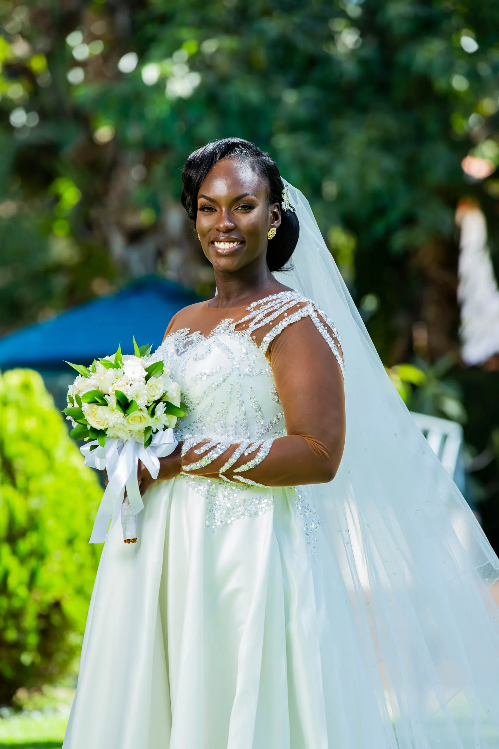 Smiling bride holding a bouquet of white roses
