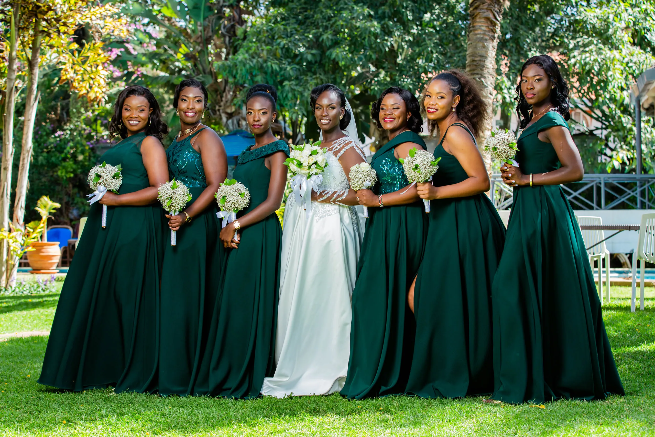 Bride with her bridesmaids in emerald gowns on the lawn